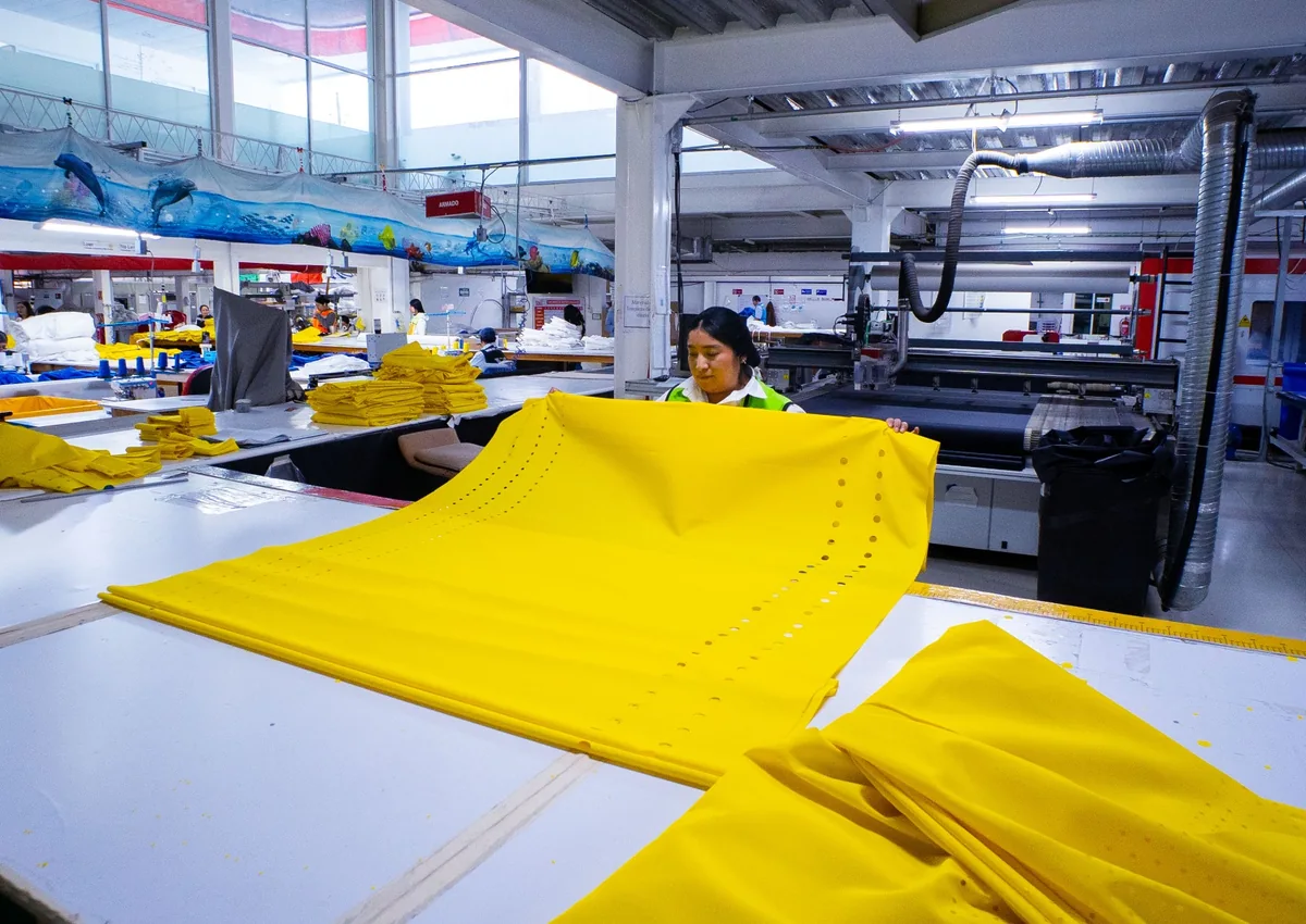 Tecido amarelo em processo de fabricação de duto têxtil