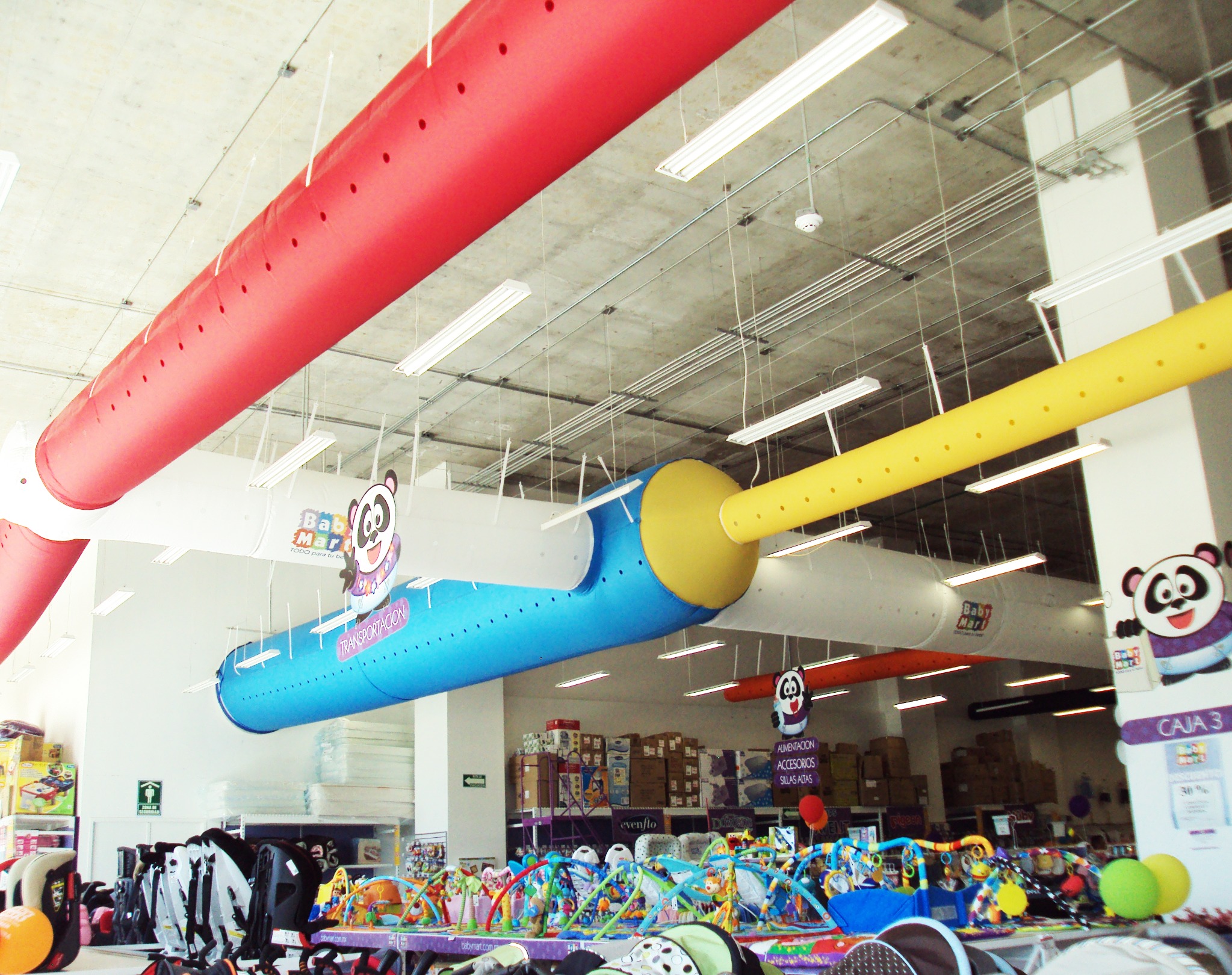 Espaço comercial com dutos têxteis coloridos instalados no teto